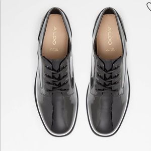 Black Almond toe oxfords grounded on a flatform.